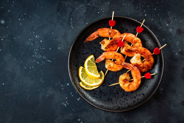 istock Fried shrimp on the black background with free space for text. Original snack for Valentine's Day, romantic dinner 1294862155