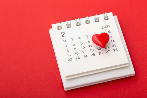 Valentines day concept with calendar and love heart on red background
