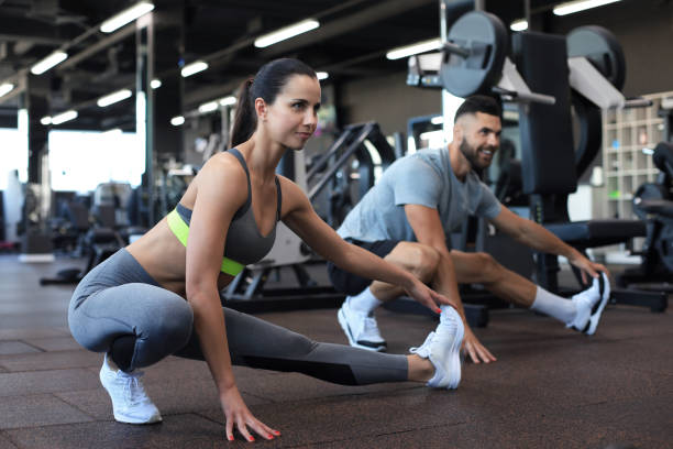 istock Two fit people doing stretching exersices in gym gym. 1294866172