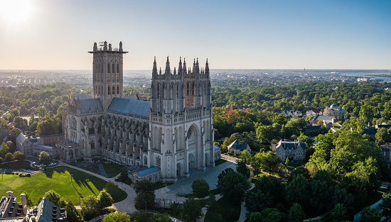 An aerial shot of the Washington National Cathedral with the District of Columbia skyline and the Potomac River in the background.
