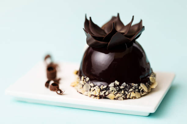 istock Chocolate sphere with almonds French pastry on white plate, over light blue background. 1294869443