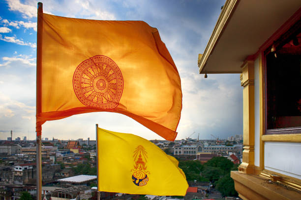 nubes de tormenta sobre la bandera de dharmachakra y la bandera hm king bhumibol adulyadej en la parte superior de la tanga phu khao o montaña dorada de wat saket, o el templo del monte dorado. bangkok, tailandia. - phumiphon aduldet fotografías e imágenes de stock