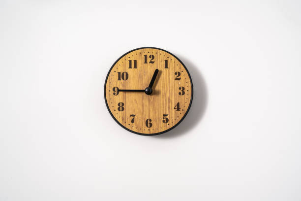 istock wood office wall clock with white dial on white background. wall clock on white background, top view. 1294873157