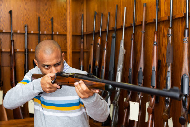 istock Portrait of confident man in gun shop showing rifle 1294873473