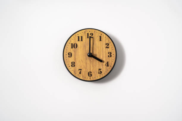 istock wood office wall clock with white dial on white background. wall clock on white background, top view. 1294874370