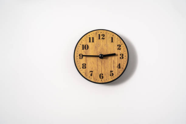 istock wood office wall clock with white dial on white background. wall clock on white background, top view. 1294874579