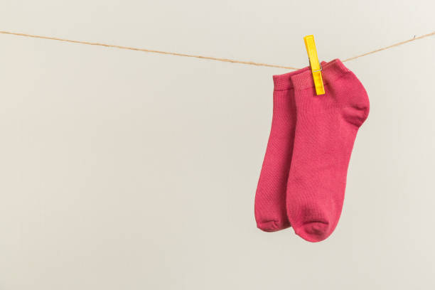istock multicolored socks, dry after washing, hanging on a clothesline with clothespins on a light background 1294875215