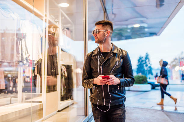istock Young man listening to music while walking 1294875250