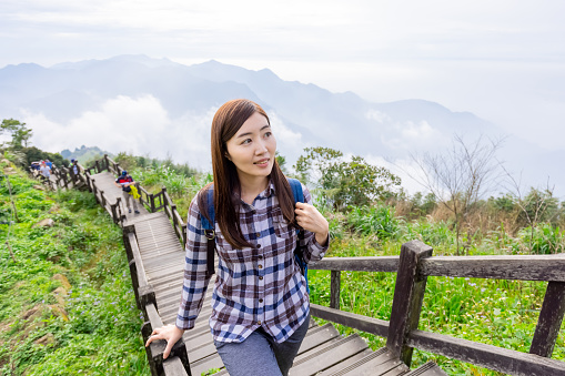 asian young woman traveler walking on hiking trail in mountains - travel healthy lifestyle