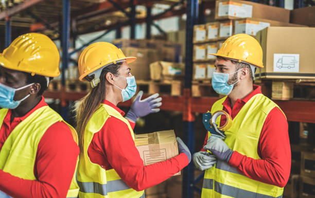 istock Multiracial staff working in warehouse with protective face masks - Industrial work 1294878898