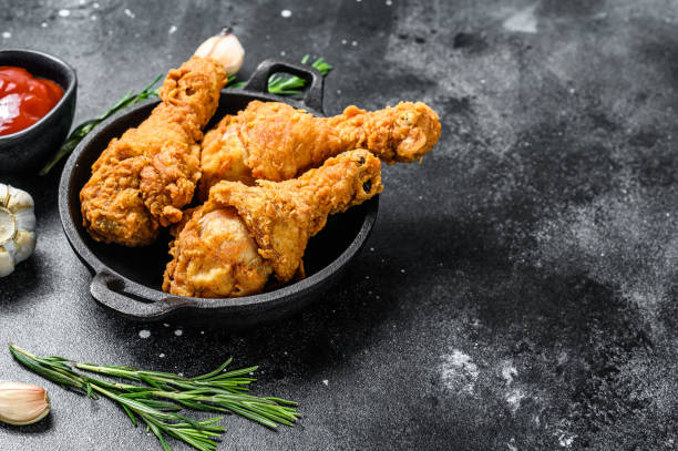 istock Spicy Deep Fried Breaded Chicken drumsticks. Black background. Top view. Copy space 1294879960