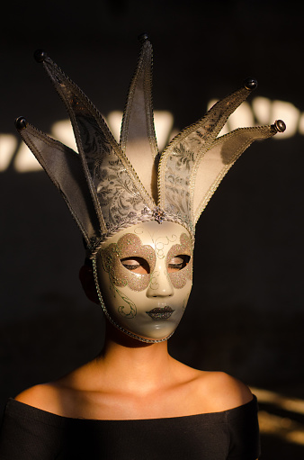 Woman with eyes closed wearing carnival mask.