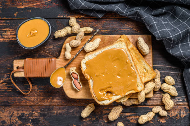 istock Crispy toast with peanut butter on breakfast.  Dark Wooden background. Top view 1294886239