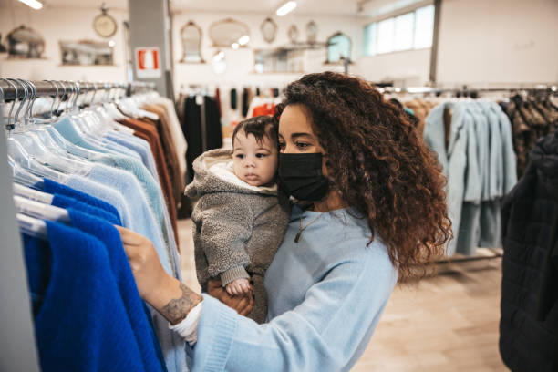 woman shopping on sales day with her baby - textile textile industry warehouse store imagens e fotografias de stock