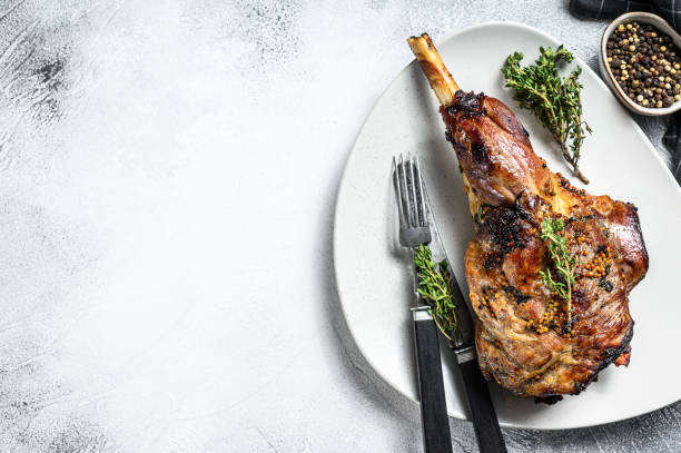 istock BBQ lamb leg with herbs. Gray background. Top view. Copy space 1294886408