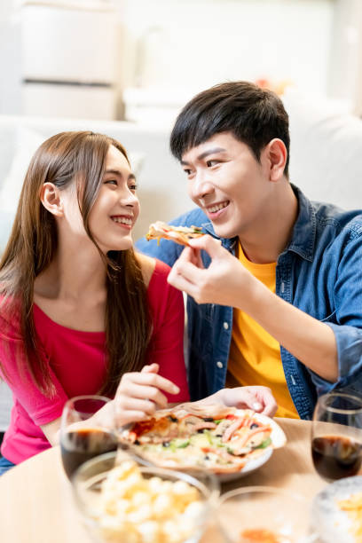 istock Asian couple eating pizza happily 1294888792