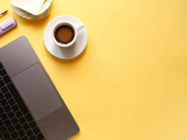 istock flat lay composition with laptop, pen, coffee on yellow background. Concept remote study and work at home, telework, freelance, quarantine. Coffee break, office table. Copyspace 1294893689