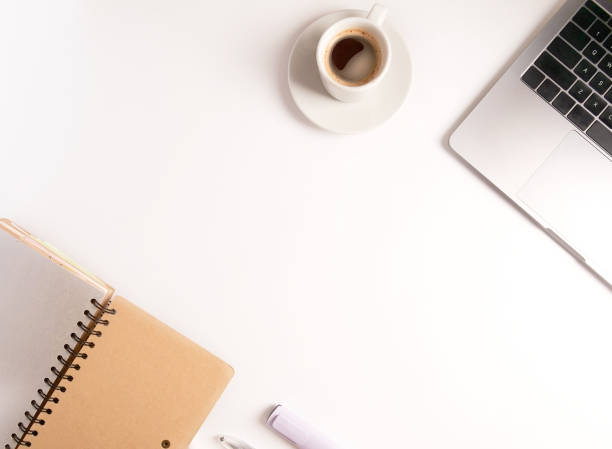 istock flat lay composition with laptop, coffee, pen and notebook on white desktop. Copyspace. Concept remote study and work at home, telework, freelance, quarantine. Online learning. 1294893728