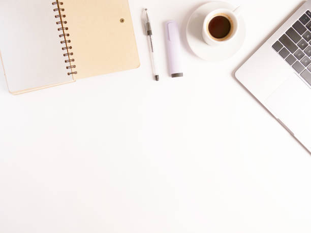 istock flat lay composition with laptop, coffee, pen and notebook on white desktop. Copyspace. Concept remote study and work at home, telework, freelance, quarantine. Distance online learning. 1294893738