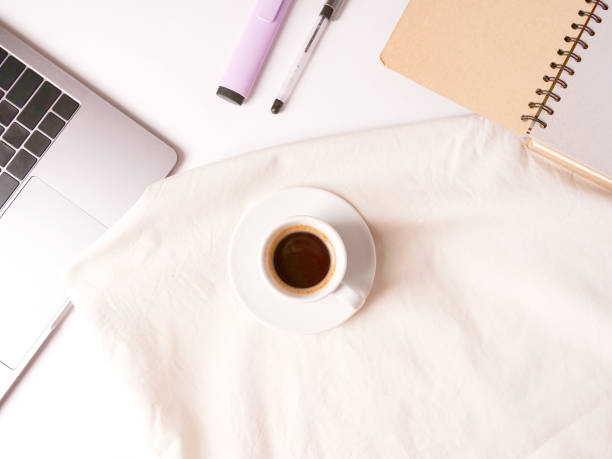 istock flat lay composition with laptop, coffee, pen, blanket and notebook on white desktop. Copyspace. Concept remote study and work at home, telework, freelance, quarantine. Distance online learning. 1294893763