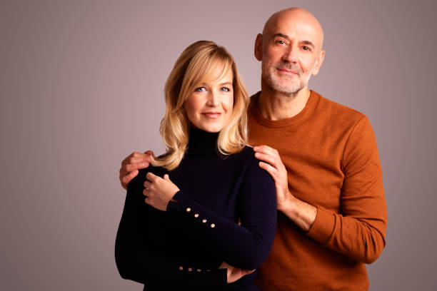 istock Lovely couple studio portrait while standing together and smiling 1294894072