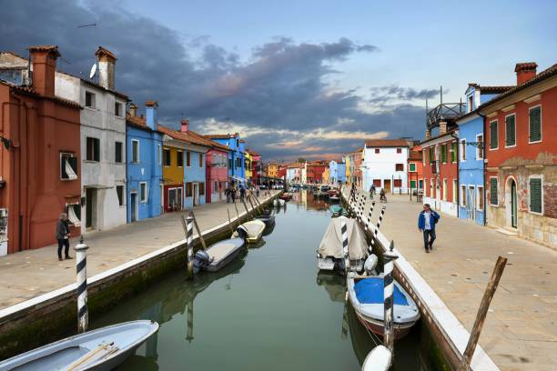 calle en un canal de agua en burano, italia - chimney lagoon island canal fotografías e imágenes de stock