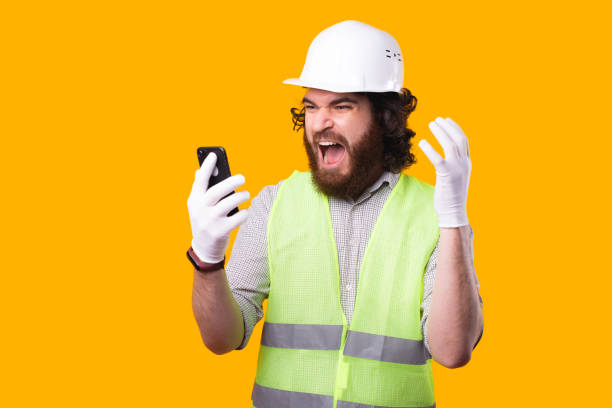 istock A bearded young engineer is looking shocked at his phone near  a yellow wall 1294894232
