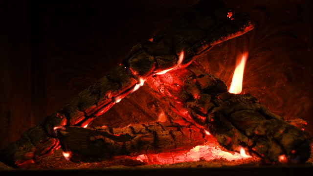 Warm cozy burning fire in a brick fireplace, close-up shot 4k