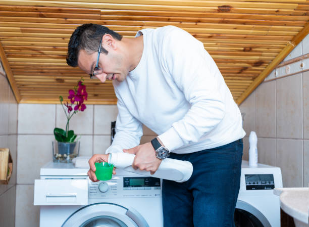 istock Young man puts detergent in washing machine. Laundry day 1294897805