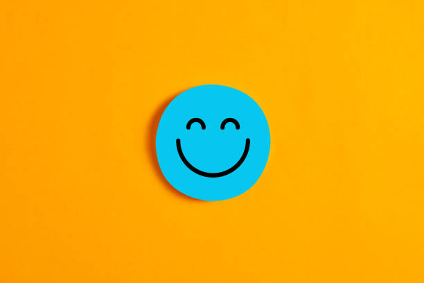 黄色の背景に対して、その上に幸せなまたは笑顔のアイコンを持つ青丸い円。