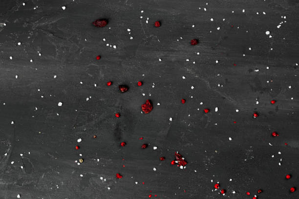 Black stone background with scattered spices, top view