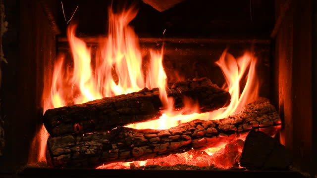 Warm cozy burning fire in a brick fireplace, close-up shot 4k