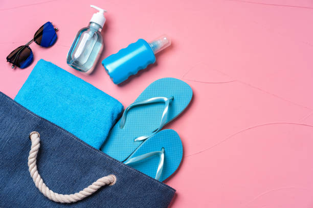 istock Beach essentials and blue beach bag on pink background 1294907343