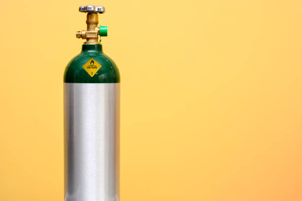 Medical Oxygen Tank Green and silver medical oxygen tank isolated on yellow background oxygen photos stock pictures, royalty-free photos & images