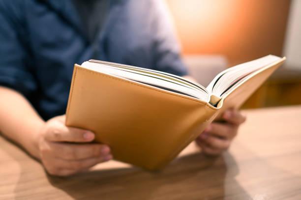 istock Male university student reading book in college library. Self learning and leisure activity. Education concept 1294910951