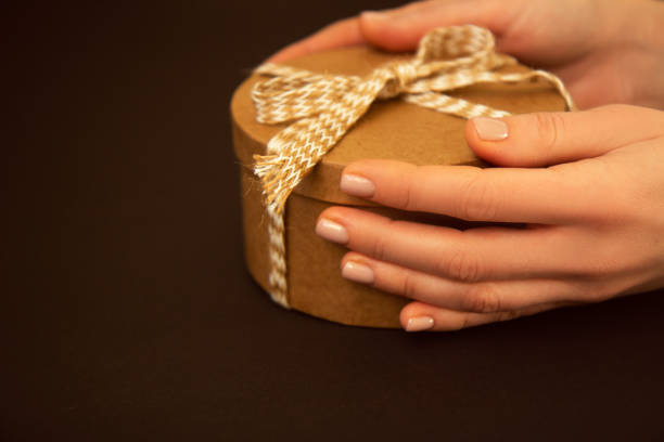istock Colorful gift with beige rope in woman's hands 1294912618