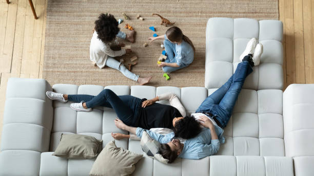 istock Top view diverse parents relaxing while little daughters playing together 1294912765