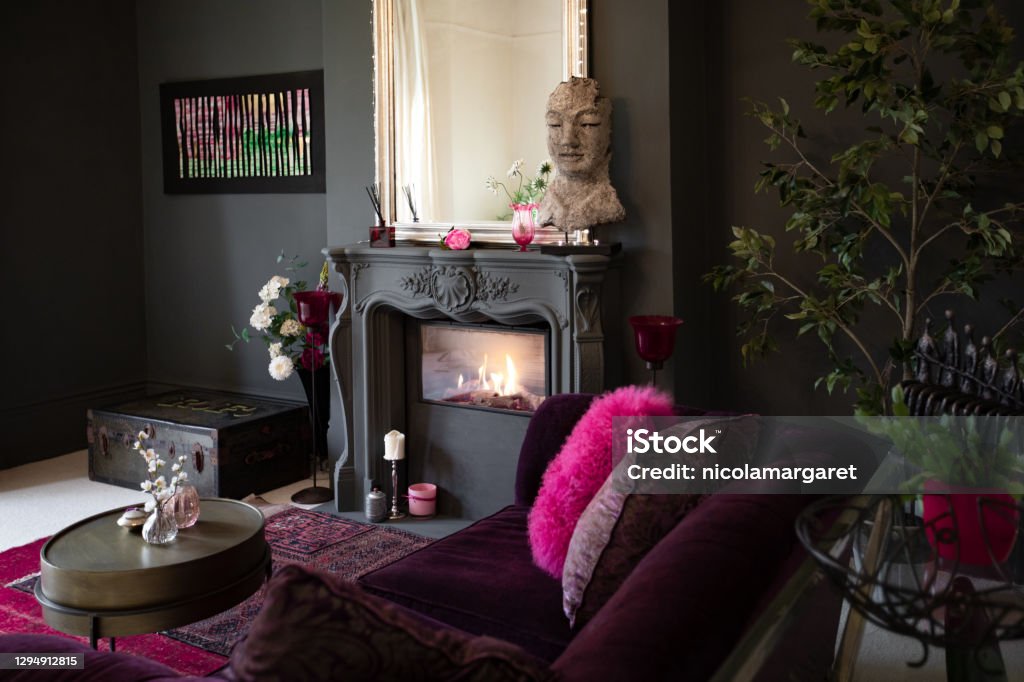 Living room with dark walls and authentic fireplace Contemporary decor, bold colour palette, luxurious textiles Home Showcase Interior Stock Photo