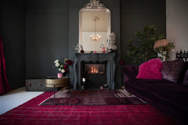 Living room with dark walls and authentic fireplace Contemporary decor, bold colour palette, luxurious textiles maroon photos stock pictures, royalty-free photos & images