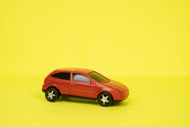 istock Toy red car close-up on a yellow background. Place for text 1294914942