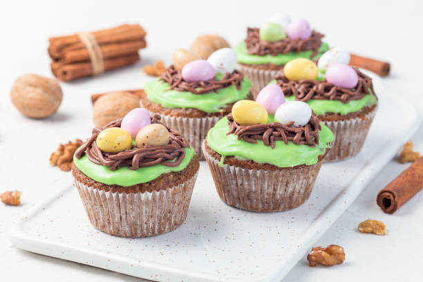 carrot cake muffins with cream cheese frosting and easter chocolate eggs, on white plate, horizontal - muffin cheese bakery breakfast imagens e fotografias de stock