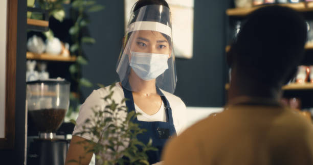 istock Multiethnic cashier and customer in cafe during coronavirus outbreak 1294920072