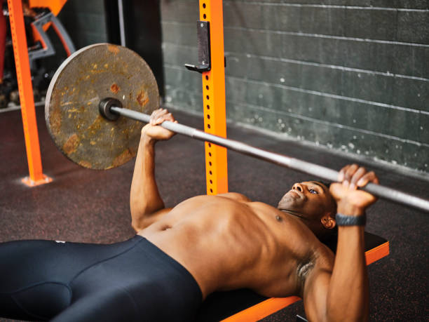 istock Man Working Out in a Gym with Barbell and Weights 1294920167