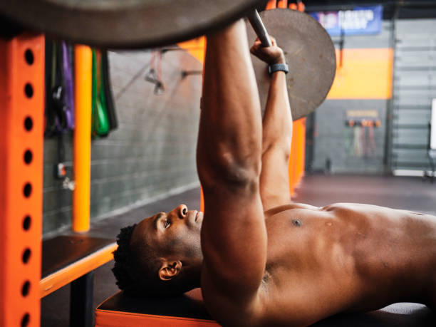 istock Man Working Out in a Gym with Barbell and Weights 1294920326