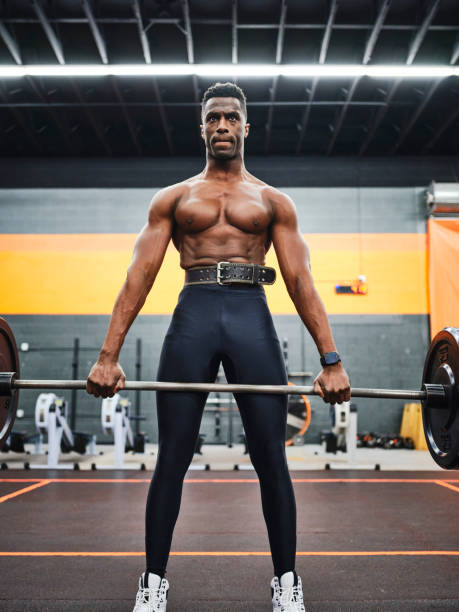 istock Man Working Out in a Gym with Barbell and Weights 1294920717