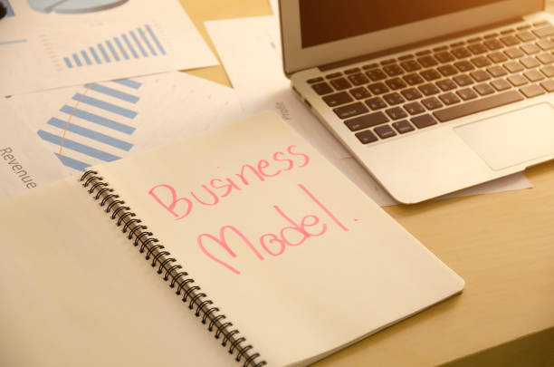 istock Business man writing business model concept in notebook on working desktop. 1294921621
