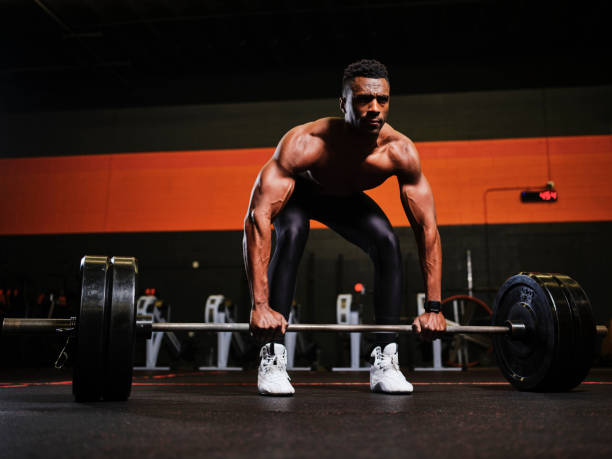 Man Working Out in a Gym with Barbell and Weights