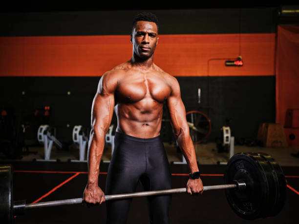 istock Man Working Out in a Gym with Barbell and Weights 1294921829