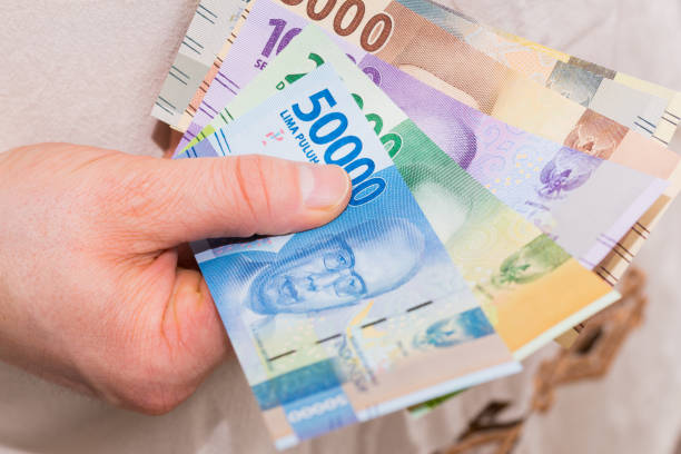 あなたの手にインドネシアのお金、様々な紙幣 - human hand beak currency stack ストックフォトと画像