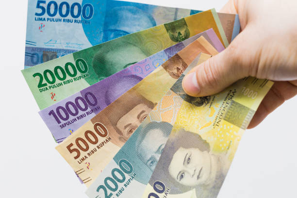 die währung indonesiens, rupiah, banknoteninschrift in der hand - human hand beak currency stack stock-fotos und bilder